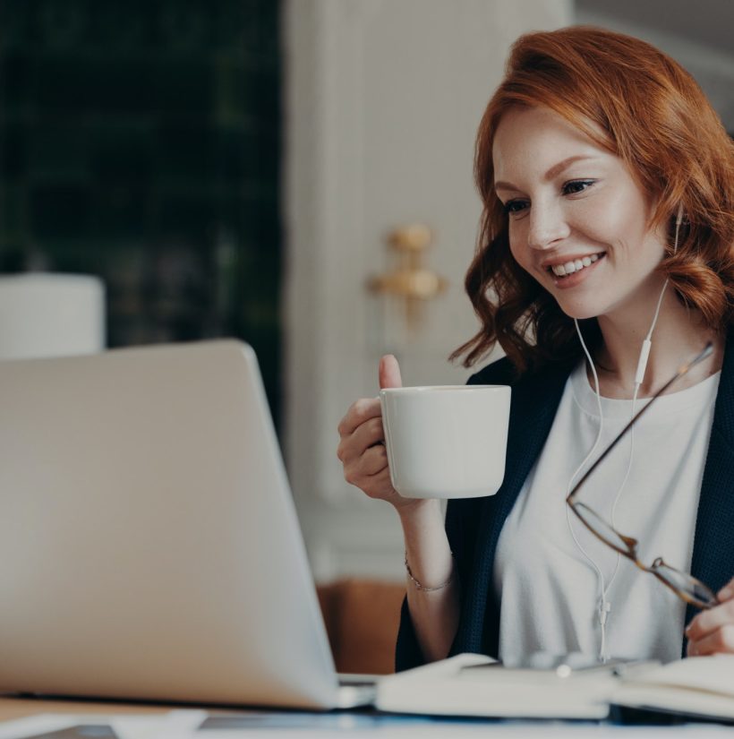 Intelligent female student has online course, concentrated in screen of laptop computer